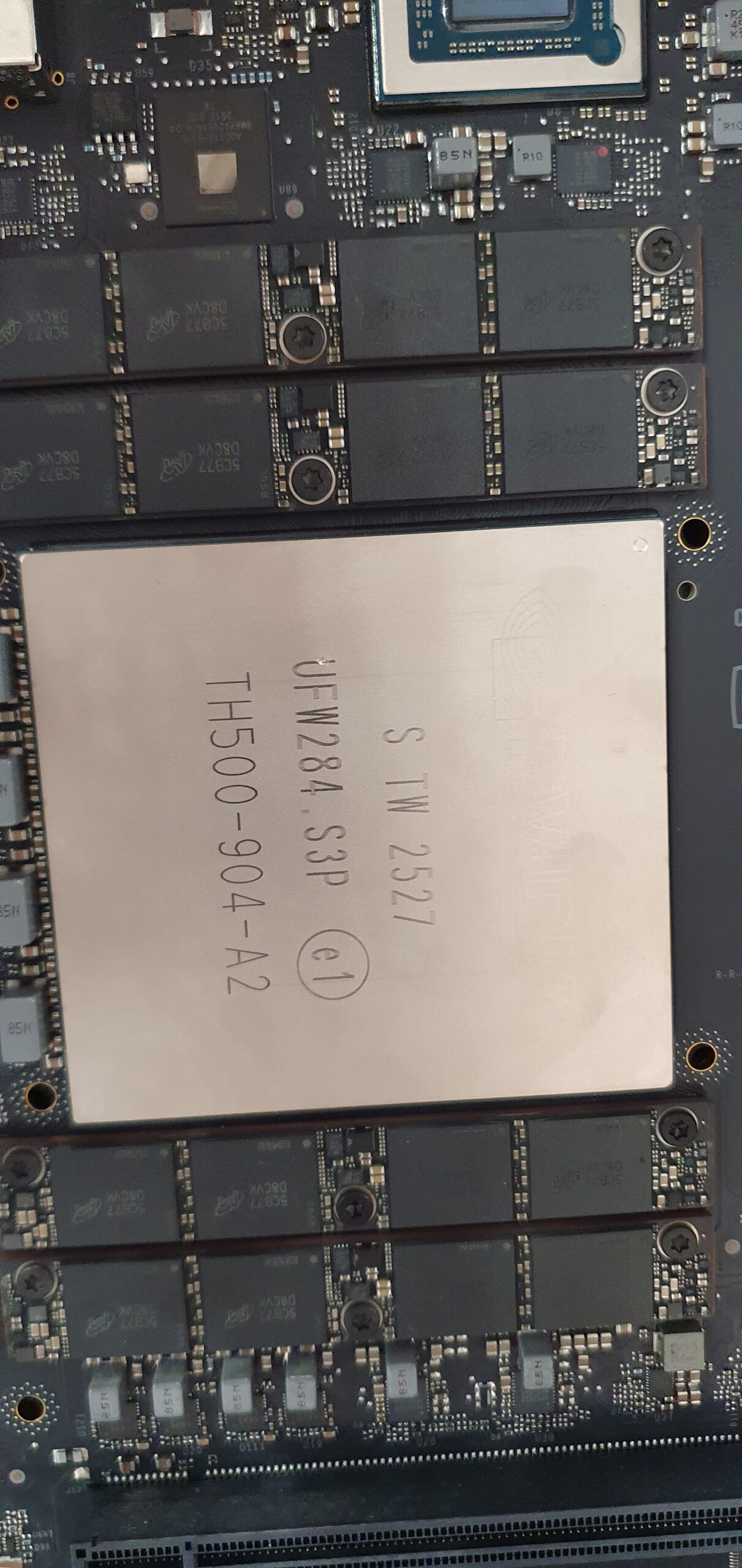 Close-up of a large chip with metal lid labeled TH500-904-A2 mounted on a circuit board surrounded by memory modules — Gigabyte W775-V10-L01 NVIDIA DGX Station GB300
