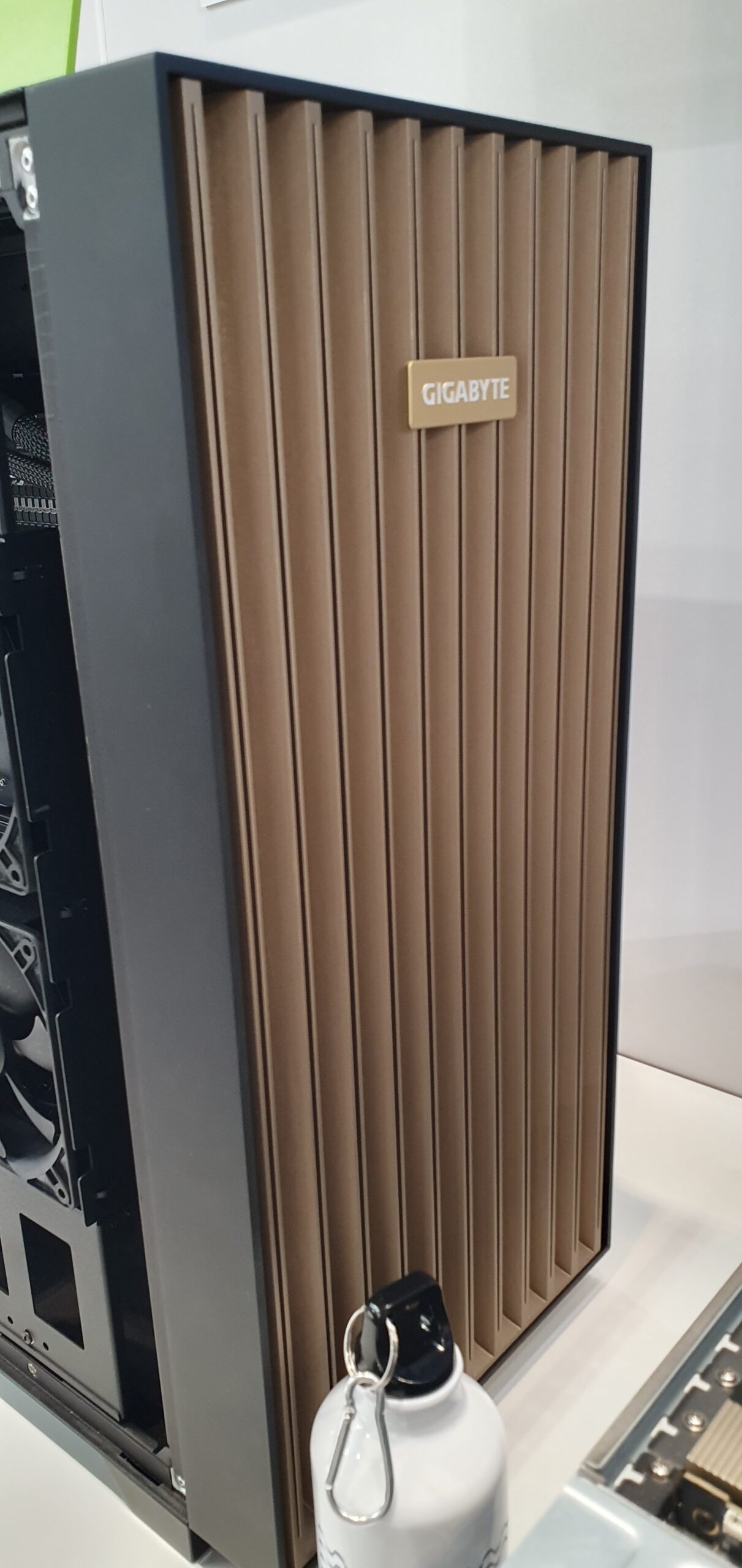 Gigabyte tower chassis with gold-toned ribbed side panel on display — Gigabyte W775-V10-L01 NVIDIA DGX Station GB300