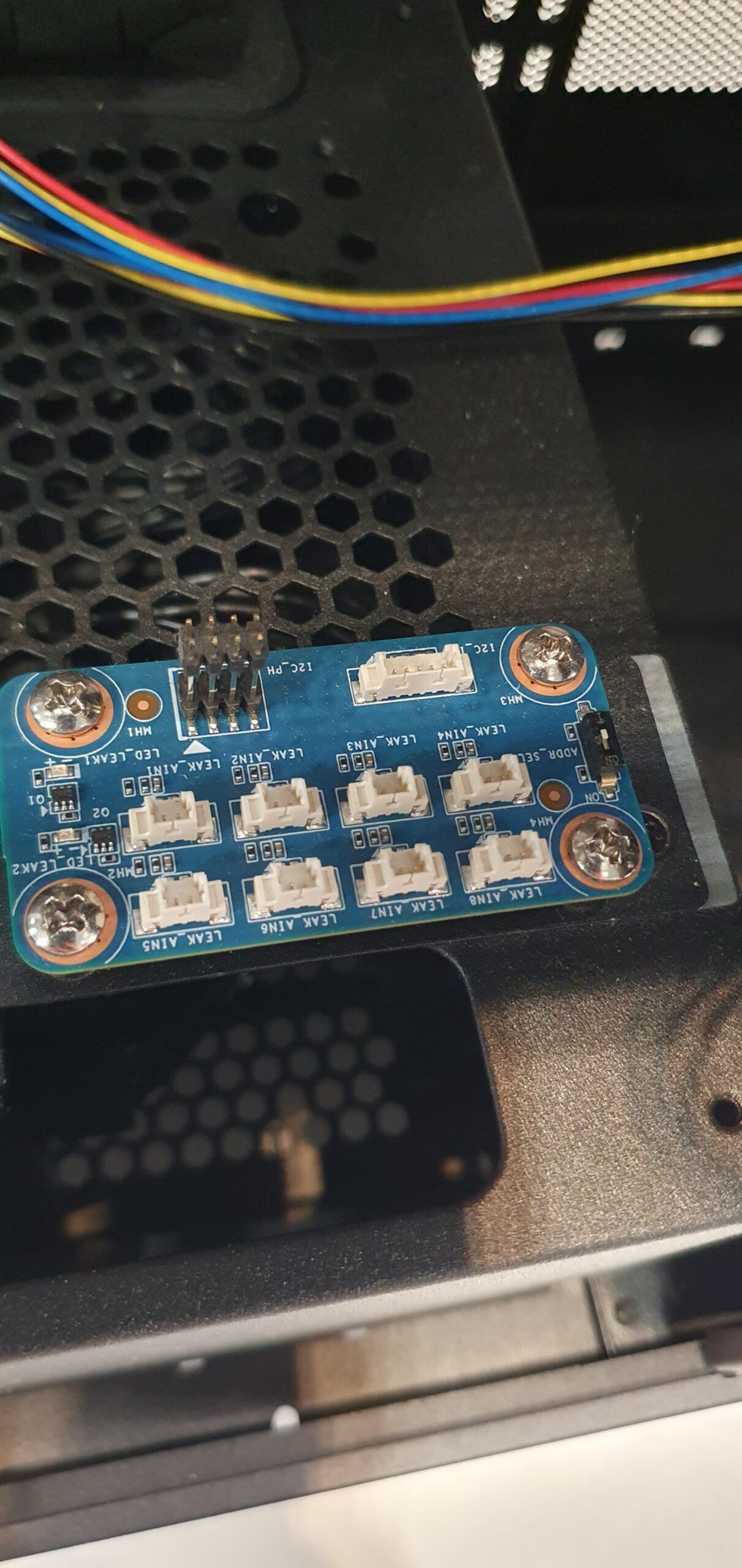 Blue PCB with multiple leak sensor connector ports mounted inside a workstation chassis — Gigabyte W775-V10-L01 NVIDIA DGX Station GB300