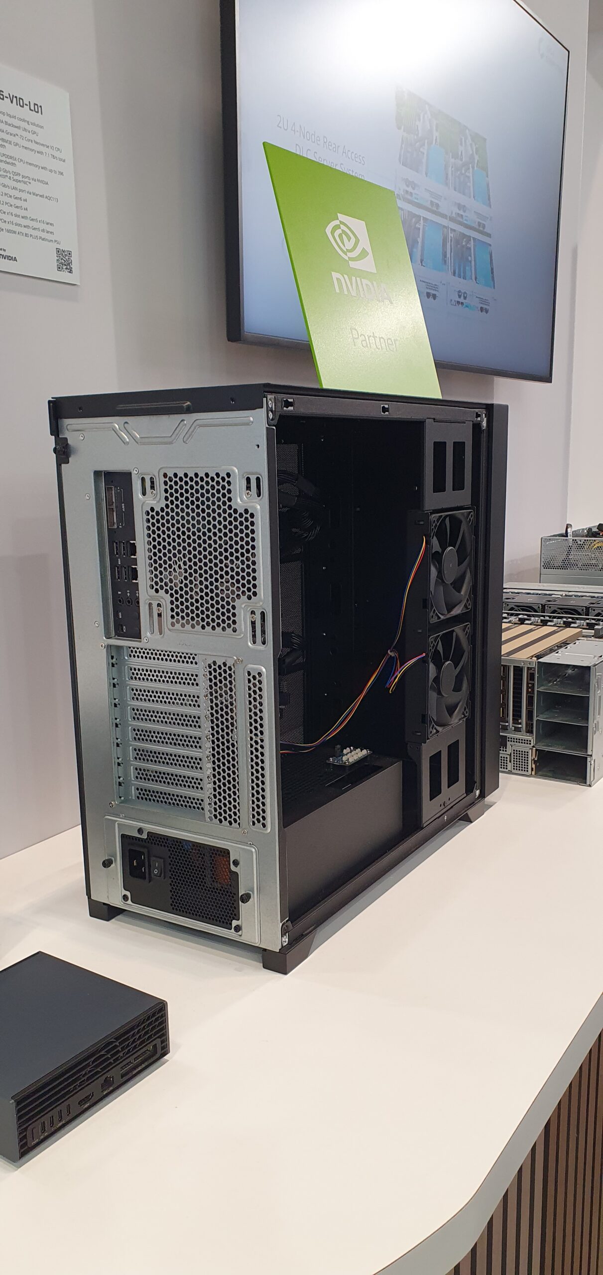 Open tower workstation chassis on display at a trade show booth with NVIDIA partner signage behind it — Gigabyte W775-V10-L01 NVIDIA DGX Station GB300