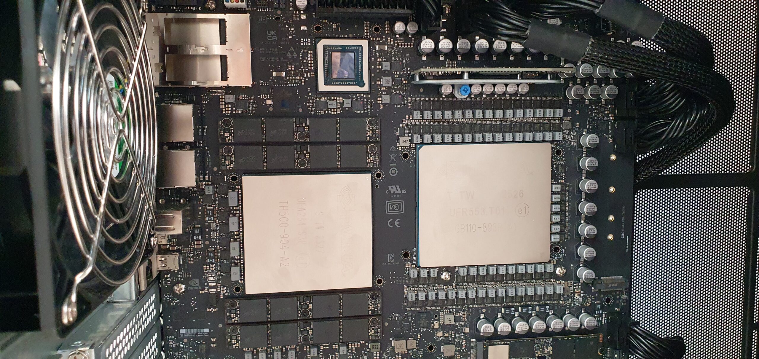 Close-up of a workstation motherboard showing large chips, VRM capacitors, and a cooling fan — Gigabyte W775-V10-L01 NVIDIA DGX Station GB300