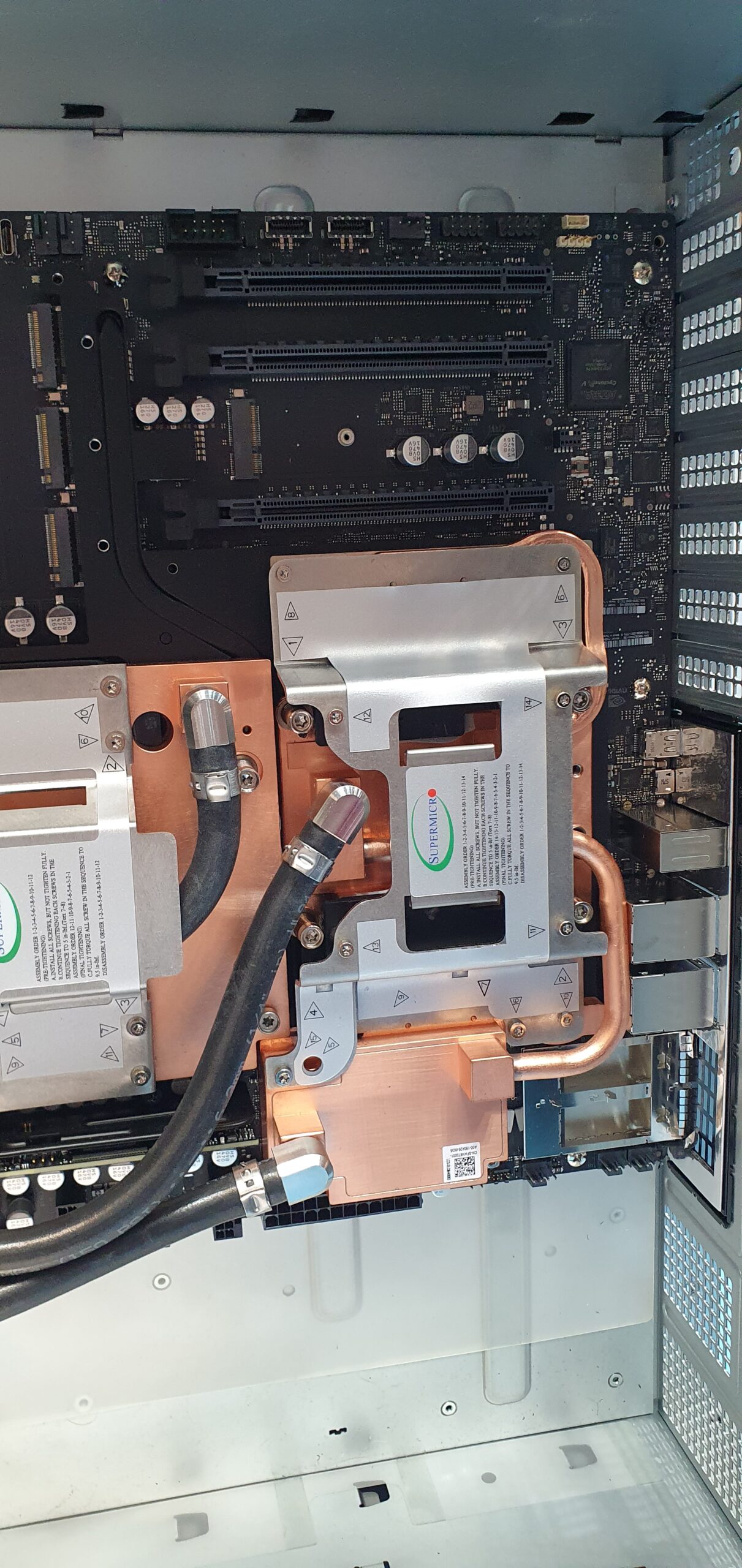 Open workstation chassis showing liquid cooling cold plates with copper tubing on motherboard — Supermicro ARS-511GD-NB-LCC NVIDIA DGX Station GB300