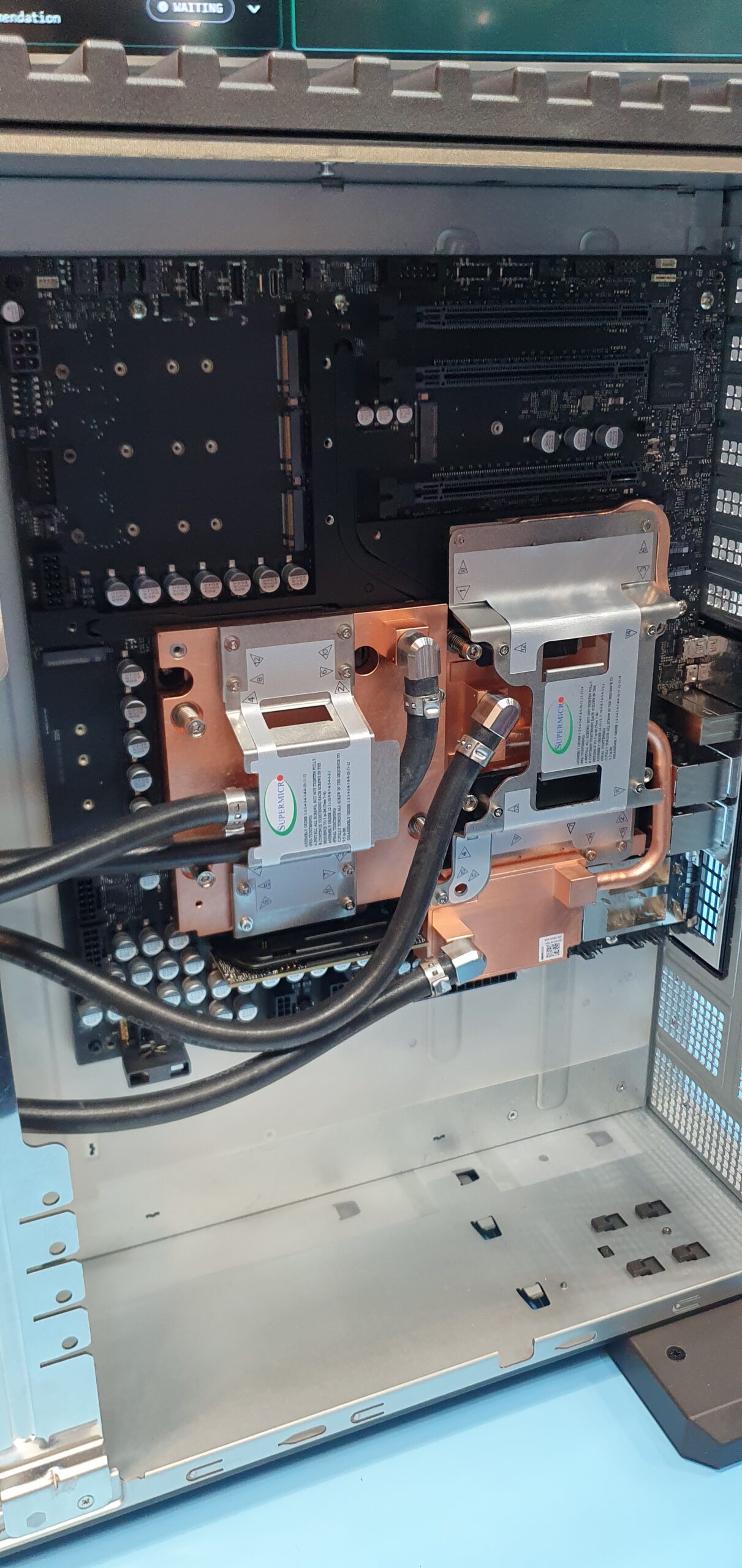 Open workstation chassis showing copper liquid cooling cold plates with hoses attached to processors — Supermicro ARS-511GD-NB-LCC NVIDIA DGX Station GB300