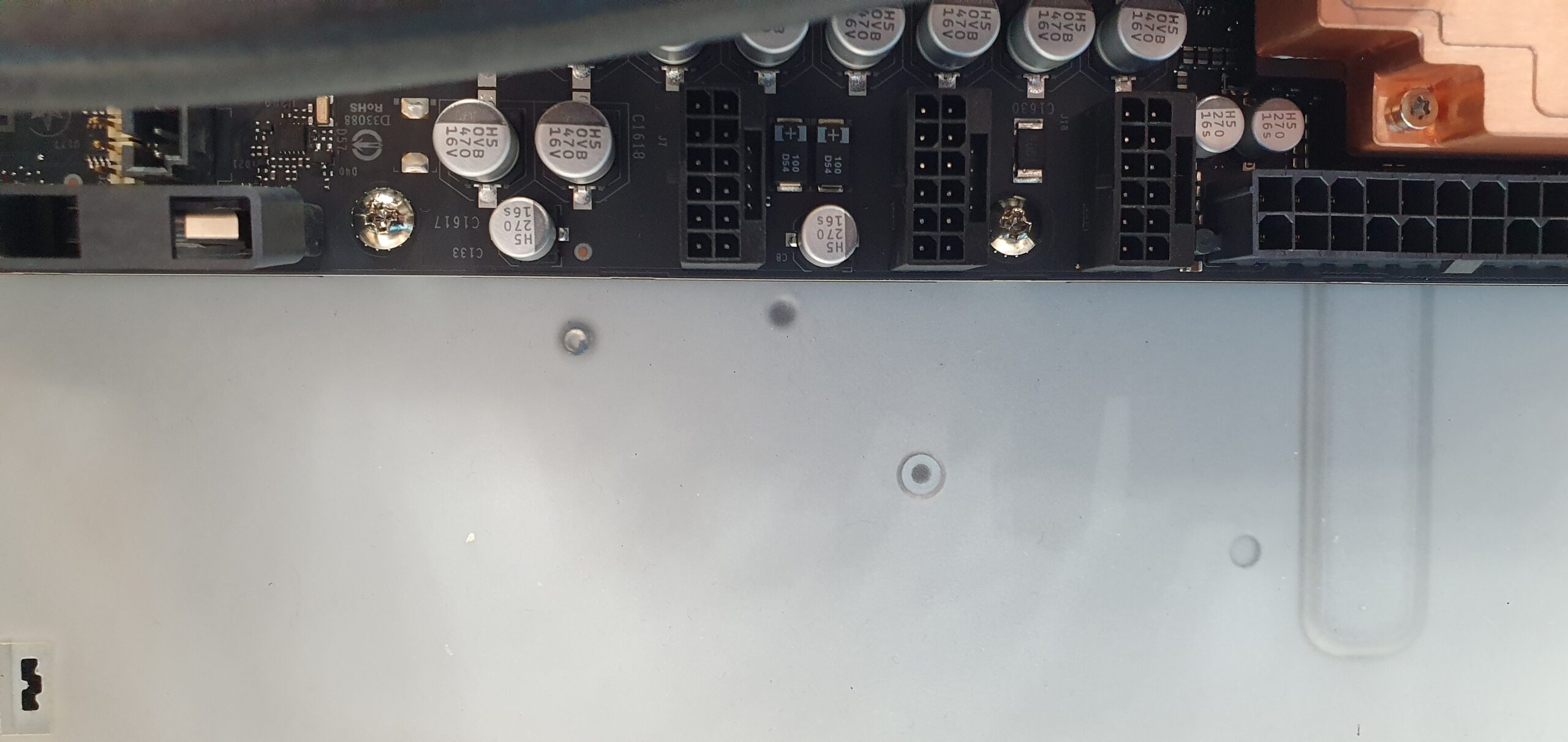 Close-up of a workstation motherboard edge showing capacitors and power connector headers — Supermicro ARS-511GD-NB-LCC NVIDIA DGX Station GB300